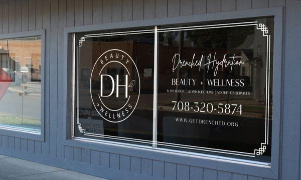 Drenched Hydration Beauty + Wellness window sign at the Pontiac clinic